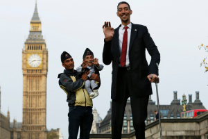 The world's shortest man Chandra Bahadur Dangi is held by nephew Dolakh Dangi as they pose with the tallest living man Sultan Kosen to mark the Guinness World Records Day in London